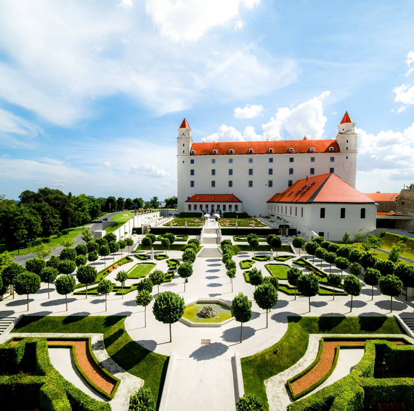 Il giardino barocco del Castello di Bratislava dall’alto, con alberi e siepi potati sotto il palazzo bianco