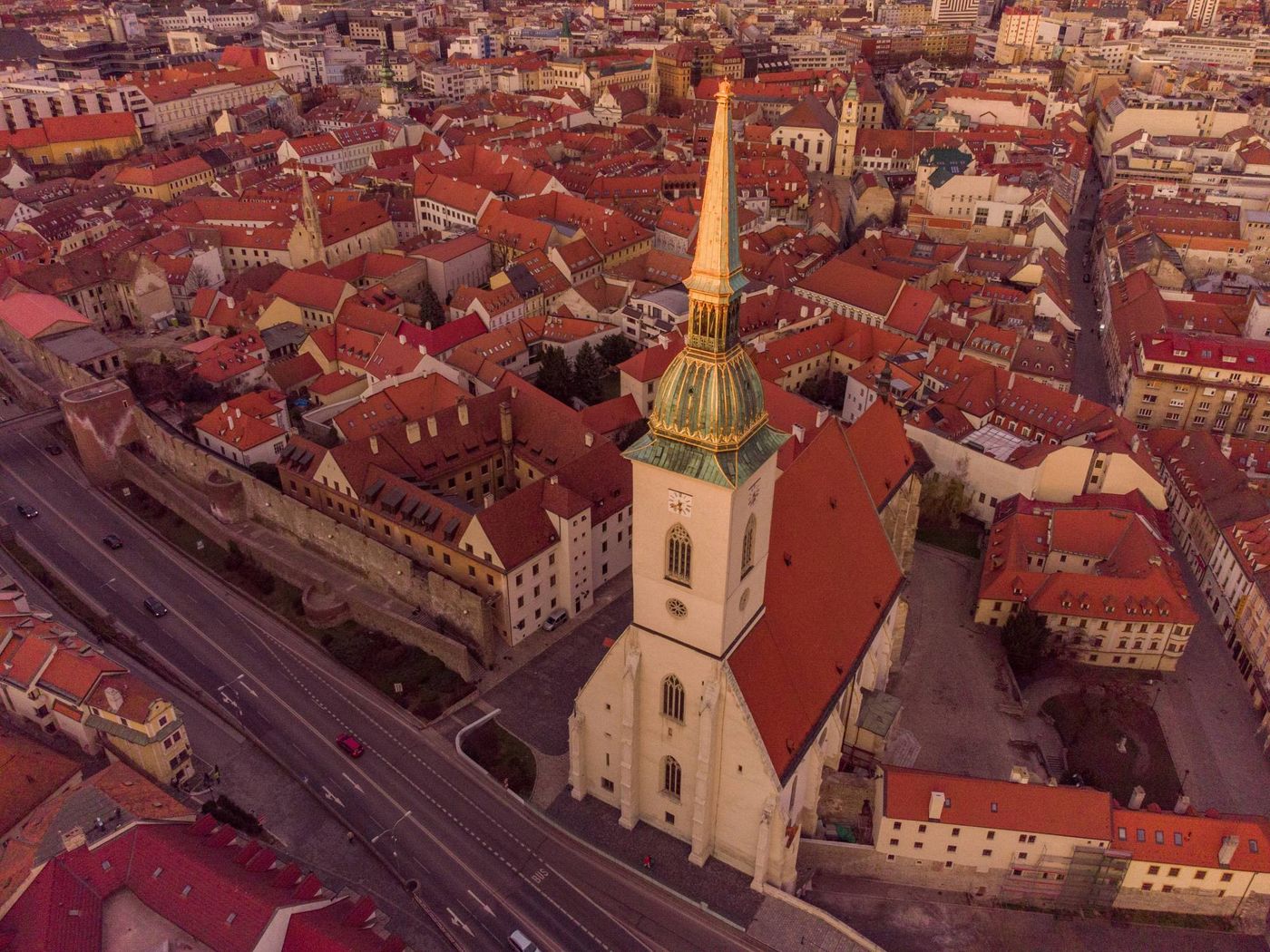 La guglia dorata della Cattedrale di San Martino dall’alto, circondata dai tetti rossi del centro storico